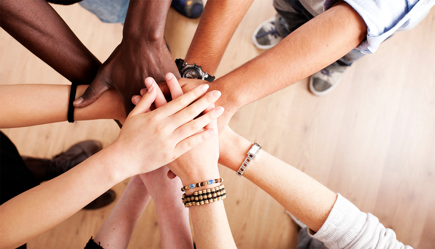 皆で手を合わせている画像